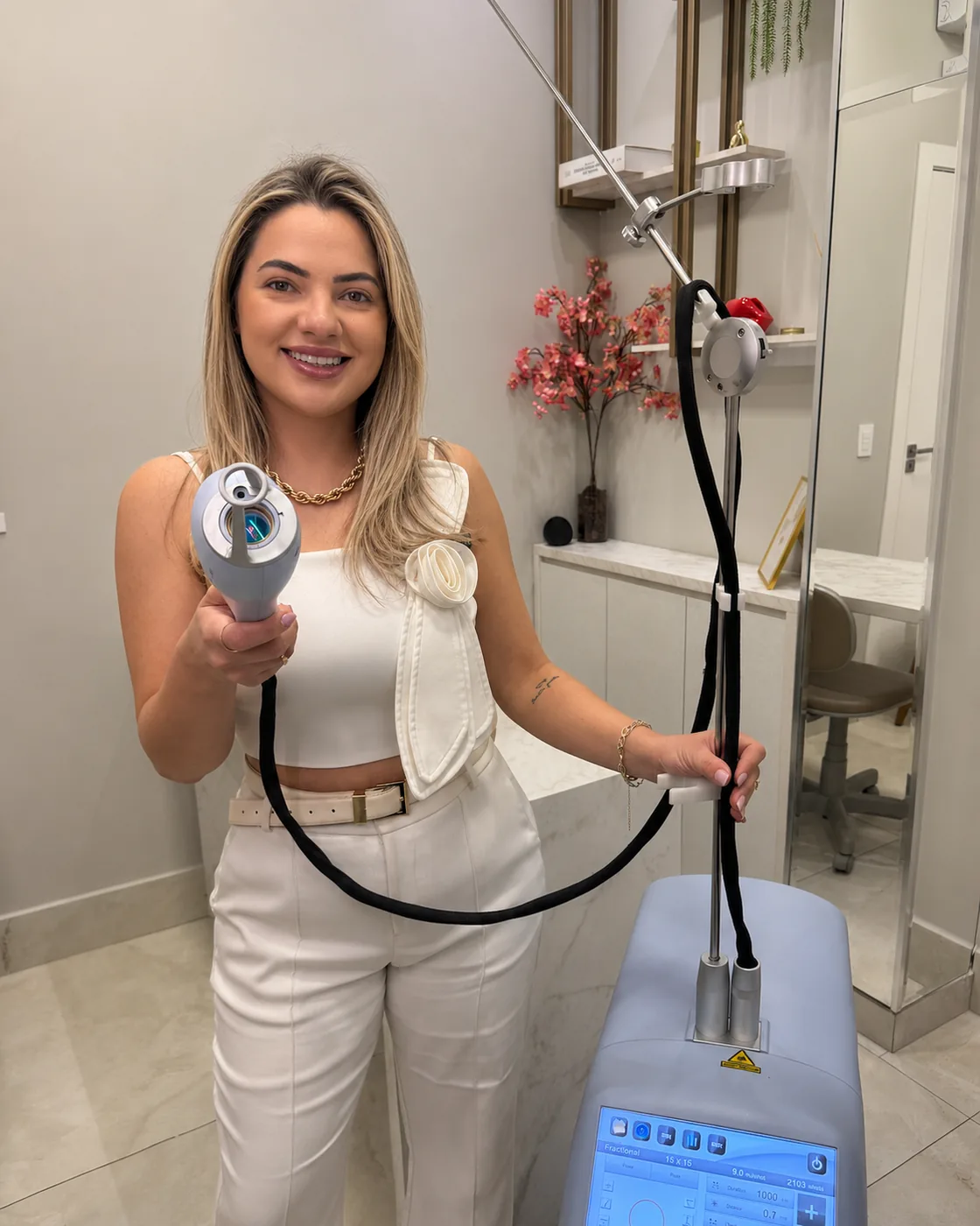Dra. Isabella Aquino com o aparelho de laser no consultório